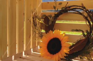 ein sonnenblumen kranz in einer holzkiste liegened mit den bergen im hintergrund