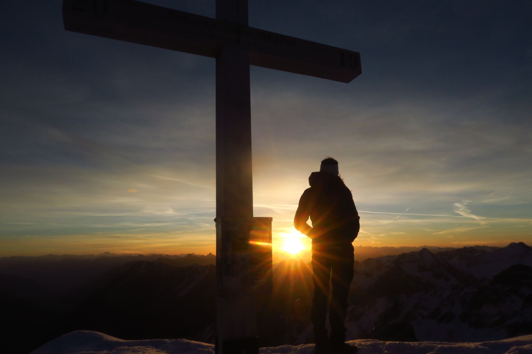 gipfelkreuz und sabrrina bei sonnenaufgang auf dem flüela schwarzhorn